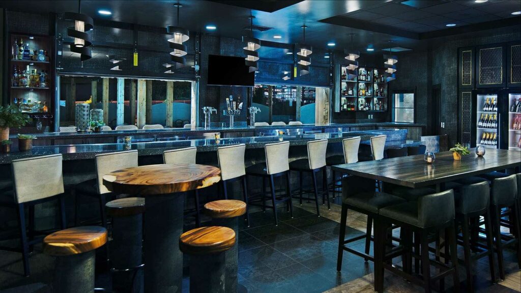 Full bar with bar stool, high tables, and many beers on tap
