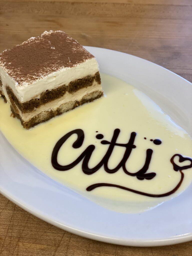 piece of tiramisu with Citti spelled out in chocolate