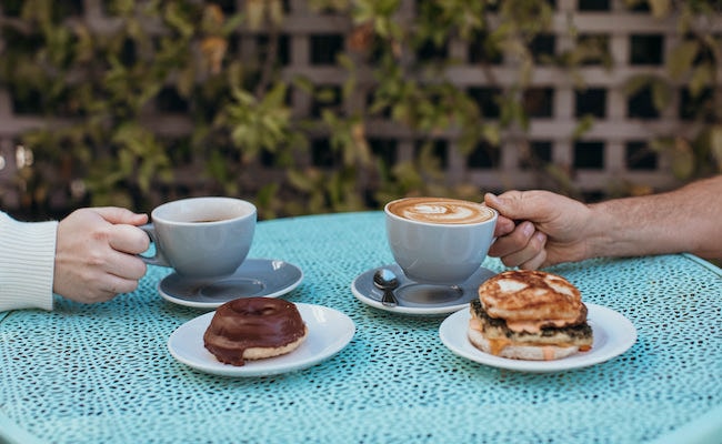 Vegan chocolate donut, house made breakfast sandwich, drip coffee & a latte