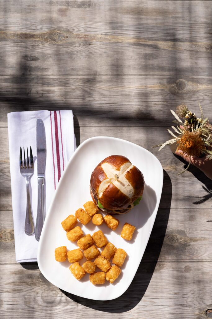Gourmet Pretzel bun burger with tater tots.